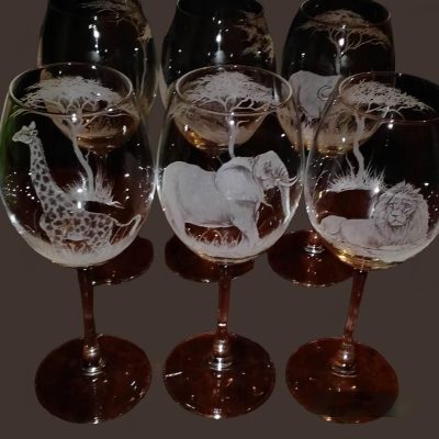 a group of wine glasses with animals and giraffes